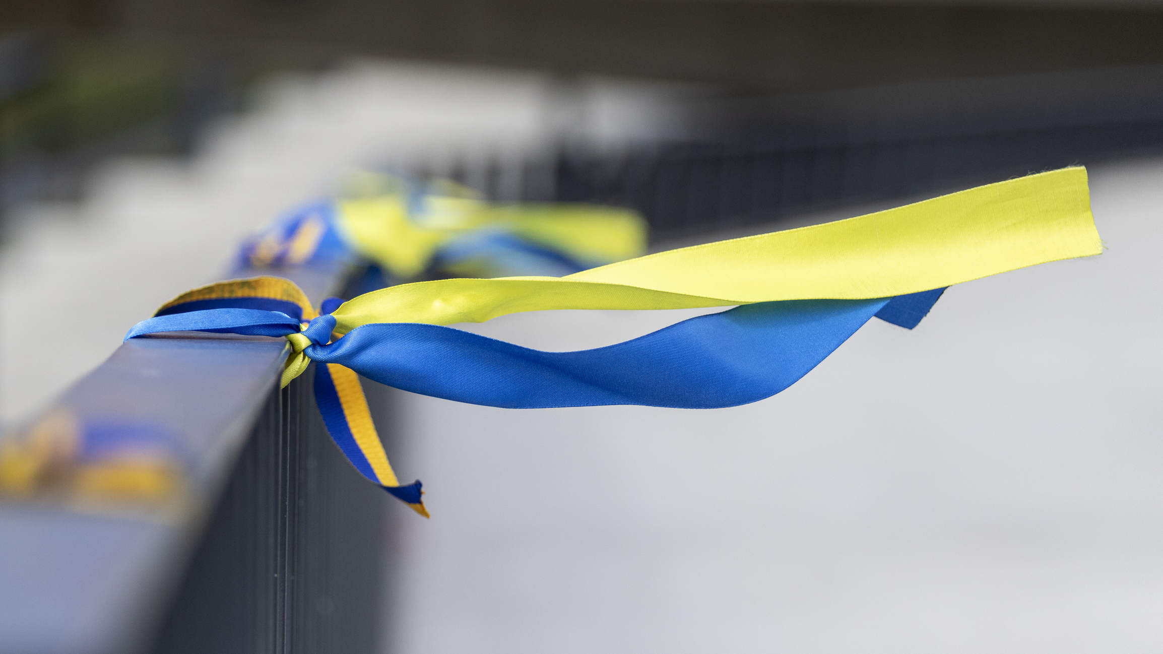 blue and yellow ribbons tied to a railing